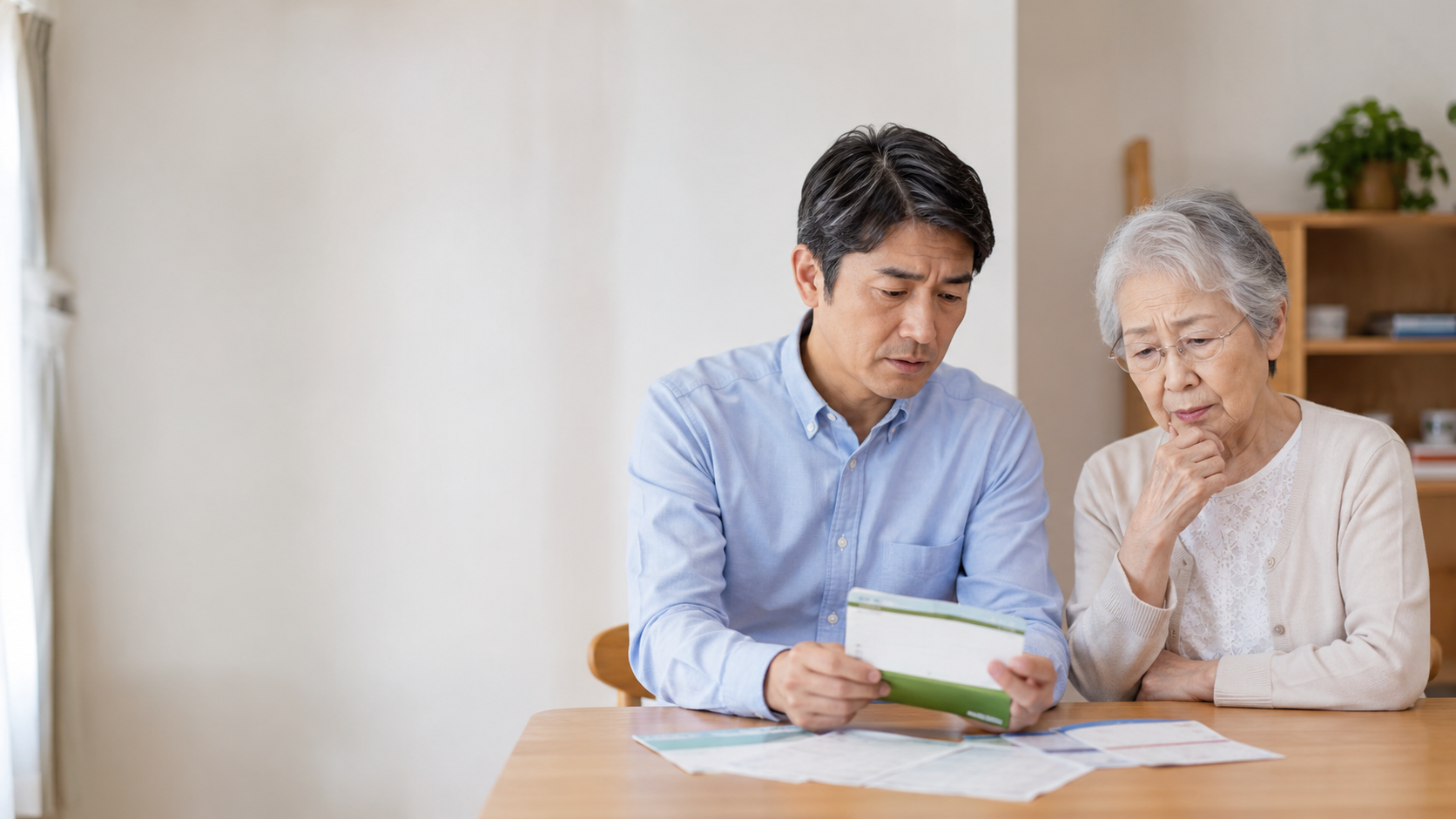 通帳を見ながら話し合う男性と高齢の女性